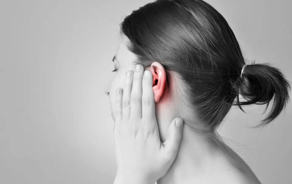 Woman pressing hand against side of her face